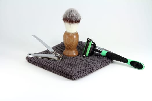 Items for a simple or rugged mens grooming and shaving. Items include razor, nail clippers, towel, and shaving cream