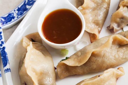 Potstickers appetizer with orange soy sauce.