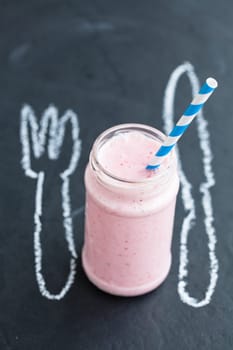 Strawberry smoothie with striped straw with knife and fork chalk drawing