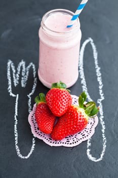 Strawberry smoothie with striped straw and whole strawberries with knife and fork chalk drawing