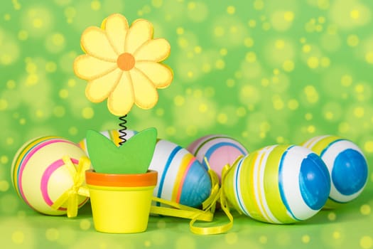 Decorative flower and Easter eggs on the green background