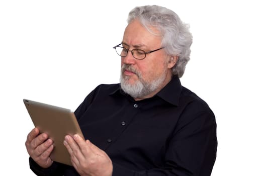 A senior with grey hair is holding a tablet and looking at it