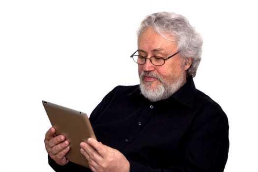 A senior with grey hair is holding a tablet and looking at it