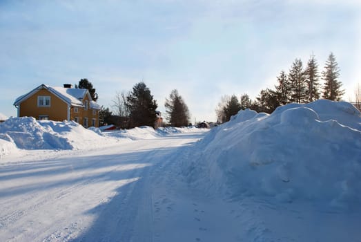 a street full of snow with some houses, snow landscape