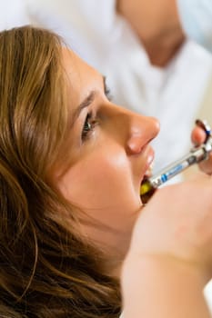 Dentist holding a syringe - anesthesia in a patient