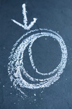 Closeup of chalk drawing of spiraling circles and arrow pointing to it