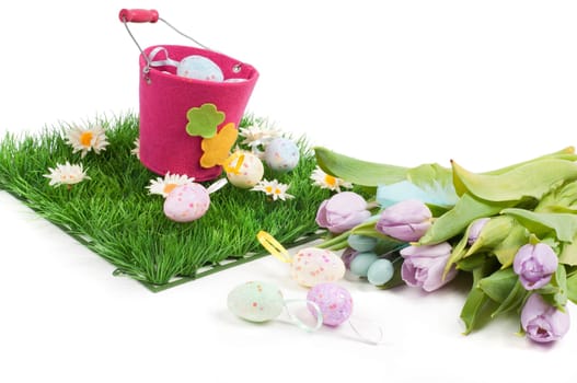 Easter composition with tulips, eggs, green grass and pail