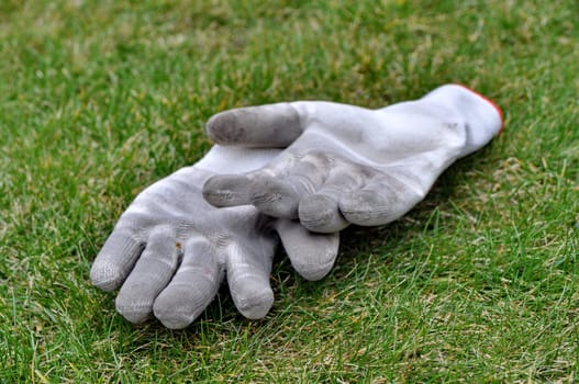 Dirty gardening gloves on the grass