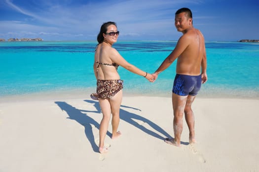 happy young asian couple have fun and romantic time at  summer on beautiful white sand beach
