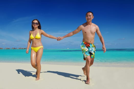 happy young asian couple have fun and romantic time at  summer on beautiful white sand beach