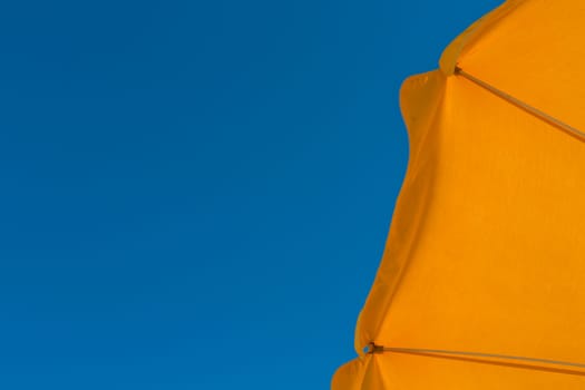 Yellow parasol against blue sky