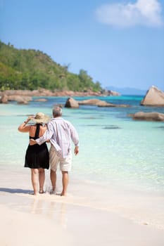 Modern couple walking on the beach - Seychelles