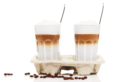 Latte macchiato to go with coffee beans on white background