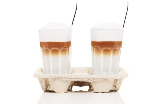 Two lattes macchiato to go on white background