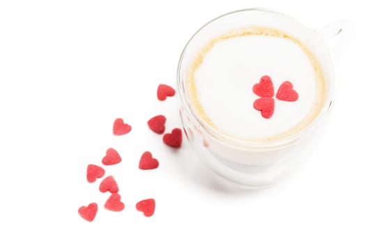 Espresso with milk foam and red sugar hearts on white background