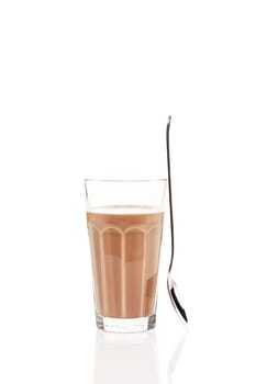 Chocolate milk with standing spoon on white background
