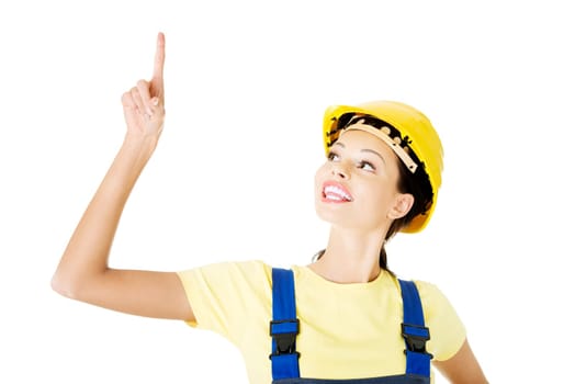 Female construction worker pointing on copy space, isolated on white