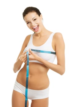 Pretty smiling woman measuring breast with measurement type - isolated on white
