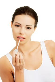 Woman putting on lip gloss, isolated on white