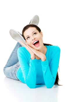 Young beautiful happy woman in casual clothes lying on floor, isolated on white