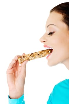 Young woman eating Cereal candy bar, isolated on white