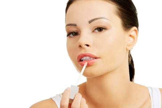 Woman putting on lip gloss, isolated on white