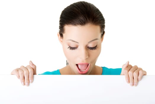 Shocked woman holding blank board, isolated on white