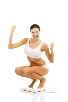 Happy woman on scales. Weight-loss concept.