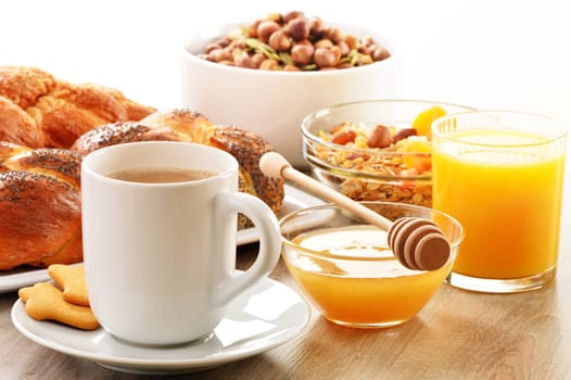 Breakfast including coffee, bread, honey, orange juice, muesli and fruits