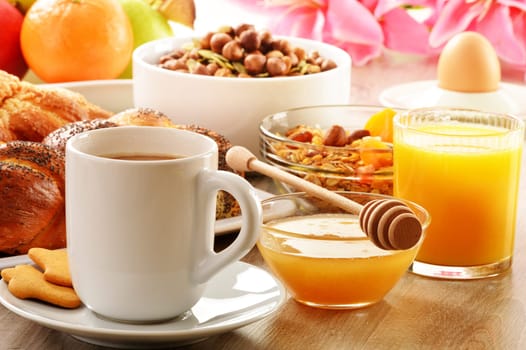 Breakfast including coffee, bread, honey, orange juice, muesli and fruits
