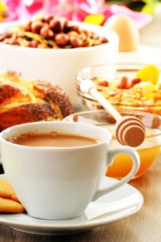 Breakfast including coffee, bread, honey, orange juice, muesli and fruits