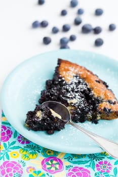 Closeup of slice of delicious blueberry pie on plate with spoon