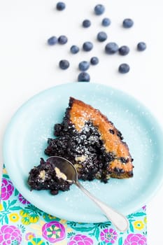 Closeup of slice of delicious blueberry pie on plate with spoon