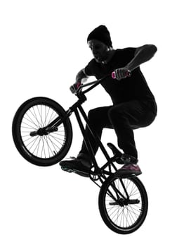 one caucasian man exercising bmx acrobatic figure in silhouette studio isolated on white background