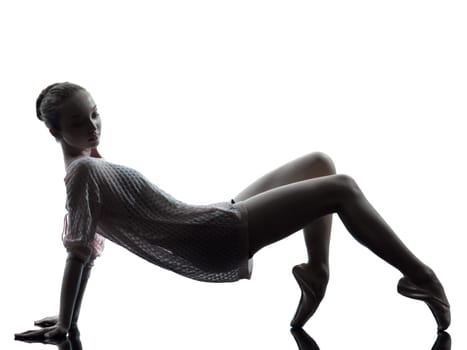 one caucasian young woman ballerina ballet dancer stretching warming up in silhouette studio on white background