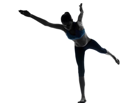 one caucasian woman exercising yoga standing on one leg in silhouette studio isolated on white background