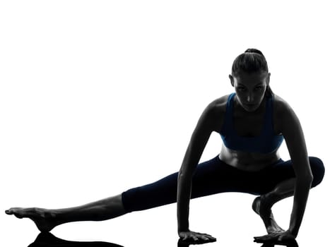 one caucasian woman exercising yoga stretching legs warm up in silhouette studio isolated on white background