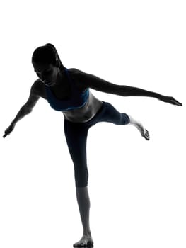 one caucasian woman exercising yoga standing on one leg in silhouette studio isolated on white background