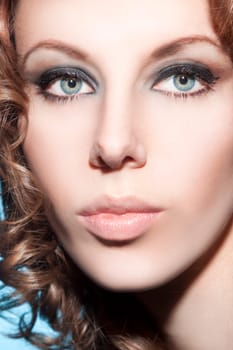 Beautiful young woman with brunette curls and perfect makeup