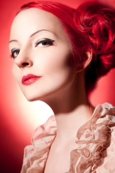 Beautiful young woman with red curls and perfect makeup