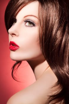 Beautiful young woman with long shiny hair and red lipstick