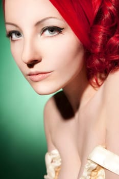 Beautiful young woman with red curls and perfect makeup