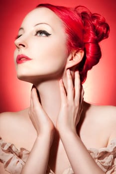 Beautiful young woman with red curls and perfect makeup