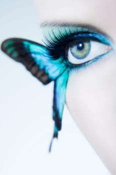 Eye of a young woman with butterfly wings
