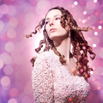 Beautiful young woman in pink with long curly hair
