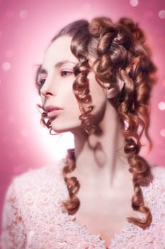 Beautiful young woman in pink with long curly hair
