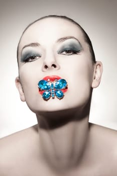 Face of a beautiful young woman with butterfly brooch