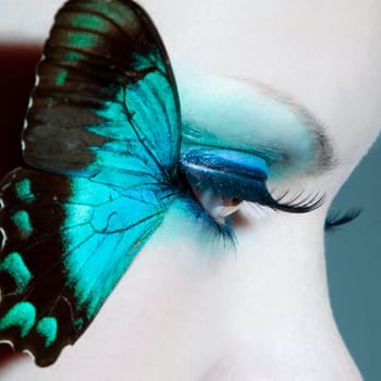 Eye of a young woman with butterfly wings