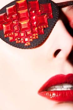 Beautiful young woman with red lips and eye patch