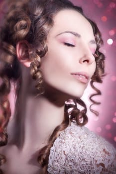 Beautiful young woman in pink with long curly hair